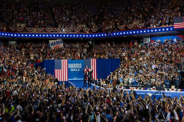 Vice President Kamala Harris and Gov. Tim Walz of Minnesota standing onstage and waving to the crowd at their first joint campaign rally on Tuesday in Philadelphia.