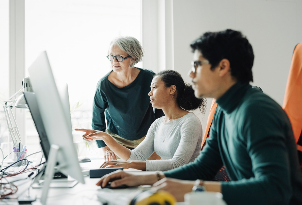 Three people in front of a computer