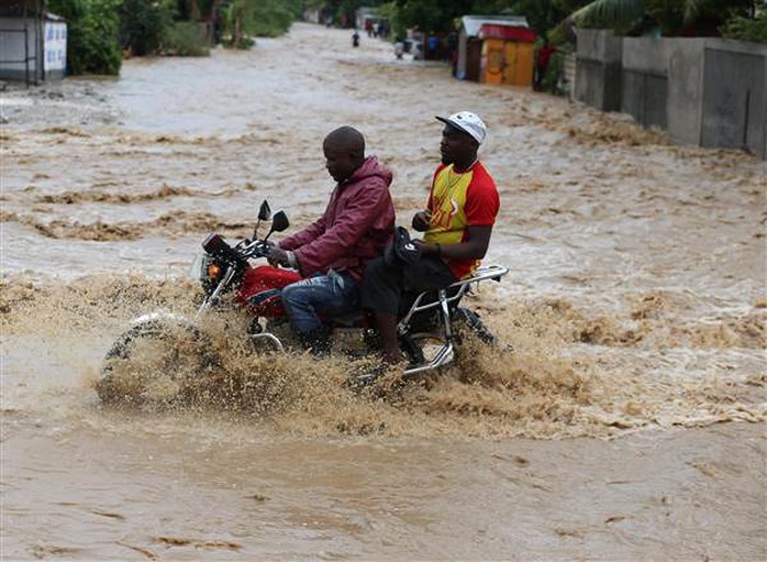 
Người dân Haiti lái xe trong nước lũ. Ảnh: EPA
